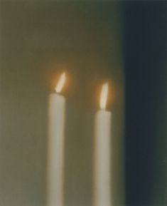 three lit candles sitting on top of a table