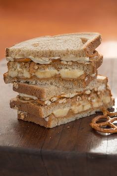 three pieces of bread with peanut butter and pretzels on them, stacked next to each other