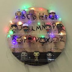 an illuminated display case with various pop vinyls on it's sides and the letters written in cursive writing