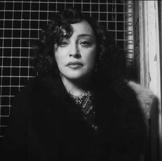 black and white photo of woman in fur coat looking off into the distance with eyes closed