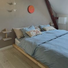 a bed with blue sheets and pillows in a room