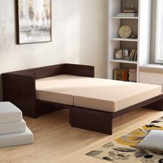 a bed sitting on top of a hard wood floor next to a book shelf filled with books