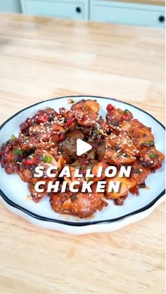 a white plate topped with chicken and sauce on top of a wooden table next to an oven