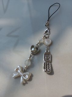 a keychain with a charm attached to it on a white tablecloth background