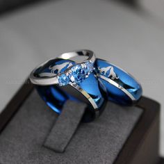 two rings with blue and white designs on them are sitting in a display case together