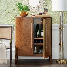 a wooden cabinet sitting next to a table with a mirror on it's side