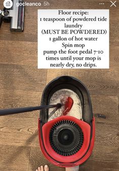 a person using a floor scruber to clean a wooden floor with a sign above it