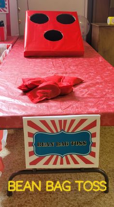 a red bag sitting on top of a table covered in pink paper and black polka dots