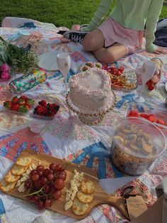 a woman sitting at a picnic table with food on the ground and in front of her