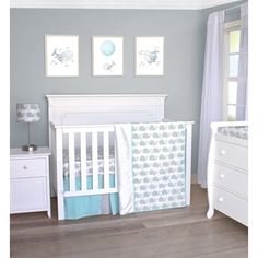 a baby's room with a crib, dresser and bedding set in it