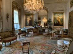 an ornately decorated living room with chandelier and paintings