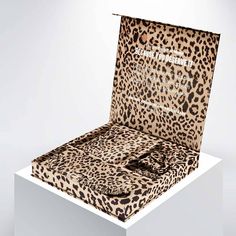 an animal print box sitting on top of a white pedestal