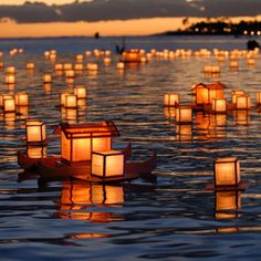 many lanterns floating on the water at night