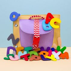 a purple bag sitting on top of a table next to colorful magnets and letters