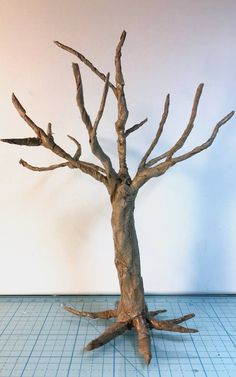 a tree that is standing in the middle of a blue tile floor with no leaves on it