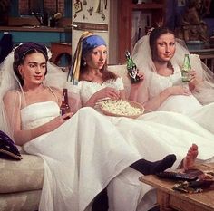 three brides sitting on a couch eating pizza and drinking beer in the living room