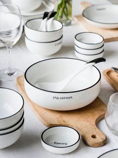 the table is set with white dishes and utensils, including one serving bowl