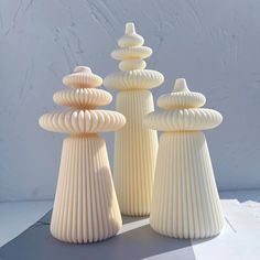 three white vases sitting next to each other on a table