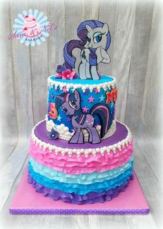 a three tiered cake decorated with pink, blue and purple ruffles