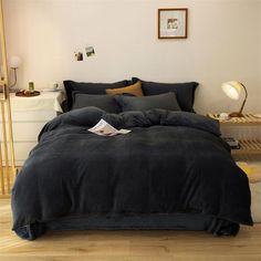 a bed with black comforter and pillows in a room