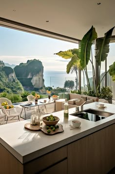 a kitchen with a large window overlooking the ocean and mountains is shown in this image