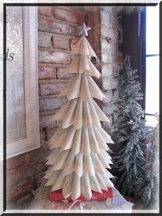 a wooden christmas tree sitting on top of a table next to a brick wall and window