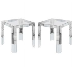 a pair of clear side tables sitting next to each other