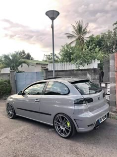 a grey car parked in front of a street light