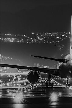 an airplane is taking off from the airport runway at night with city lights in the background