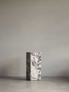 two marble blocks sitting on top of a floor next to each other in front of a gray wall