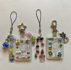 three key chains with charms attached to them