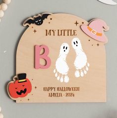 a wooden sign that says, my little b is happy halloween and two ghost hands