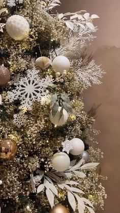 a christmas tree decorated with white and gold ornaments