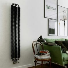 a living room filled with furniture and a radiator mounted to the wall next to a green couch