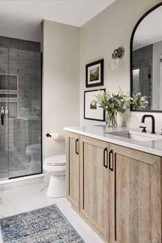 a bathroom with two sinks, a toilet and a walk - in shower next to a large mirror