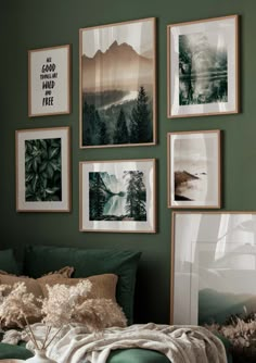 a bedroom with green walls and pictures hanging on the wall above the bed in front of it