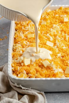 cheese being poured into a casserole dish