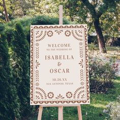 a welcome sign in front of some bushes and trees with the words,'welcome to the wedding of isabiella & oscar '