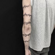 a man's arm with barbed wire tattoo on the upper arm and lower arm