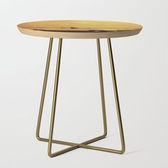 a small stool with a multicolored stripe design on the top and gold legs