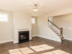 an empty living room with wood floors and a fireplace