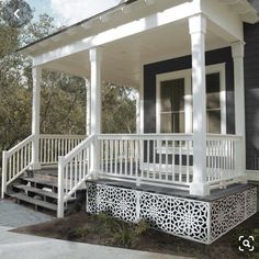 a small white house with porch and stairs