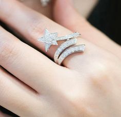 a woman's hand wearing a ring with two stars on the middle and one in the middle