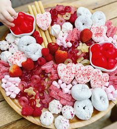 a wooden plate topped with lots of heart shaped treats