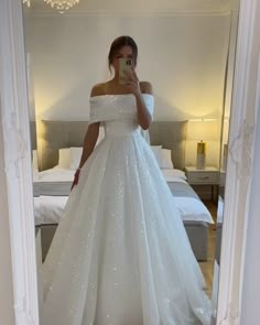 a woman is taking a selfie in her wedding dress while standing in front of a mirror