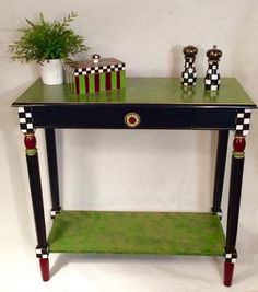 a green and black table with two vases on it's shelf next to a potted plant