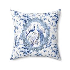 a blue and white pillow with a peacock on it