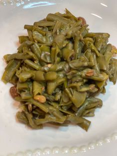 a white plate topped with green beans and nuts