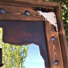 a mirror that is made out of wood and has blue glass on the bottom half