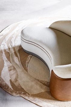 a white chair sitting on top of a rug next to a wooden object in front of it